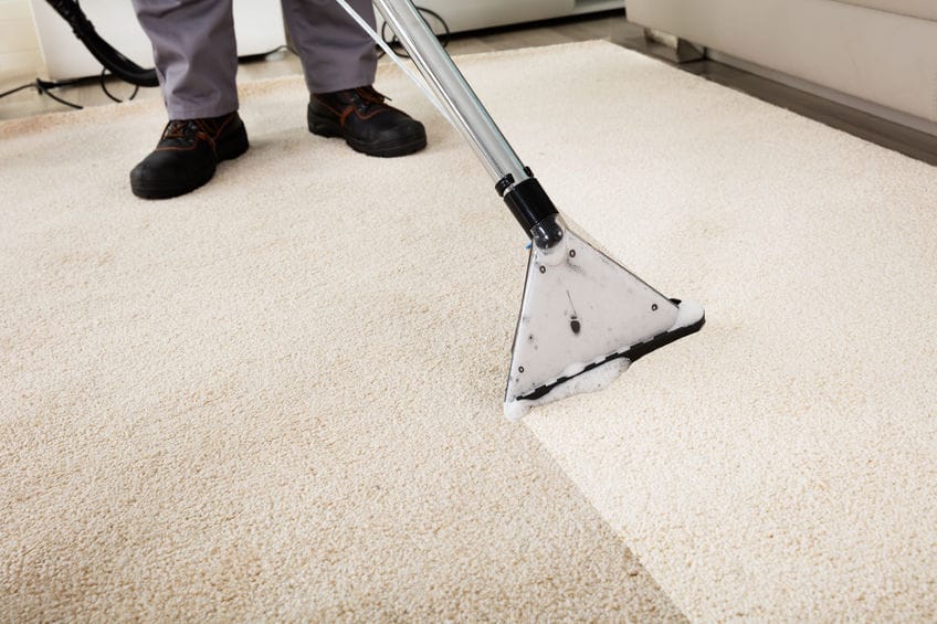 69611456 - close-up of a person cleaning carpet with vacuum cleaner Grindvloer schoonmaken