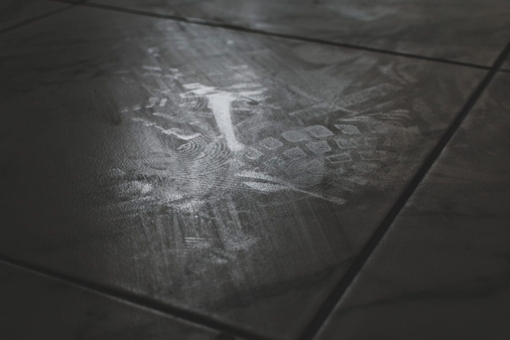 Vervuilde tegelvloer, streperig en plakkerig.